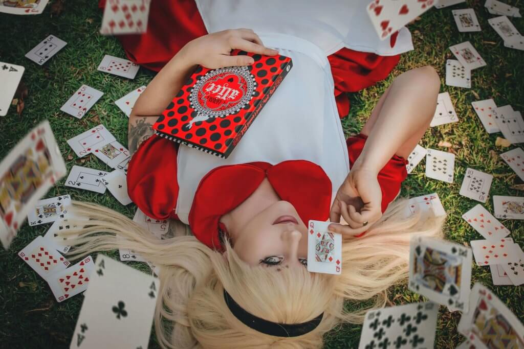 Desiree vestida de Alice com cartas de baralho